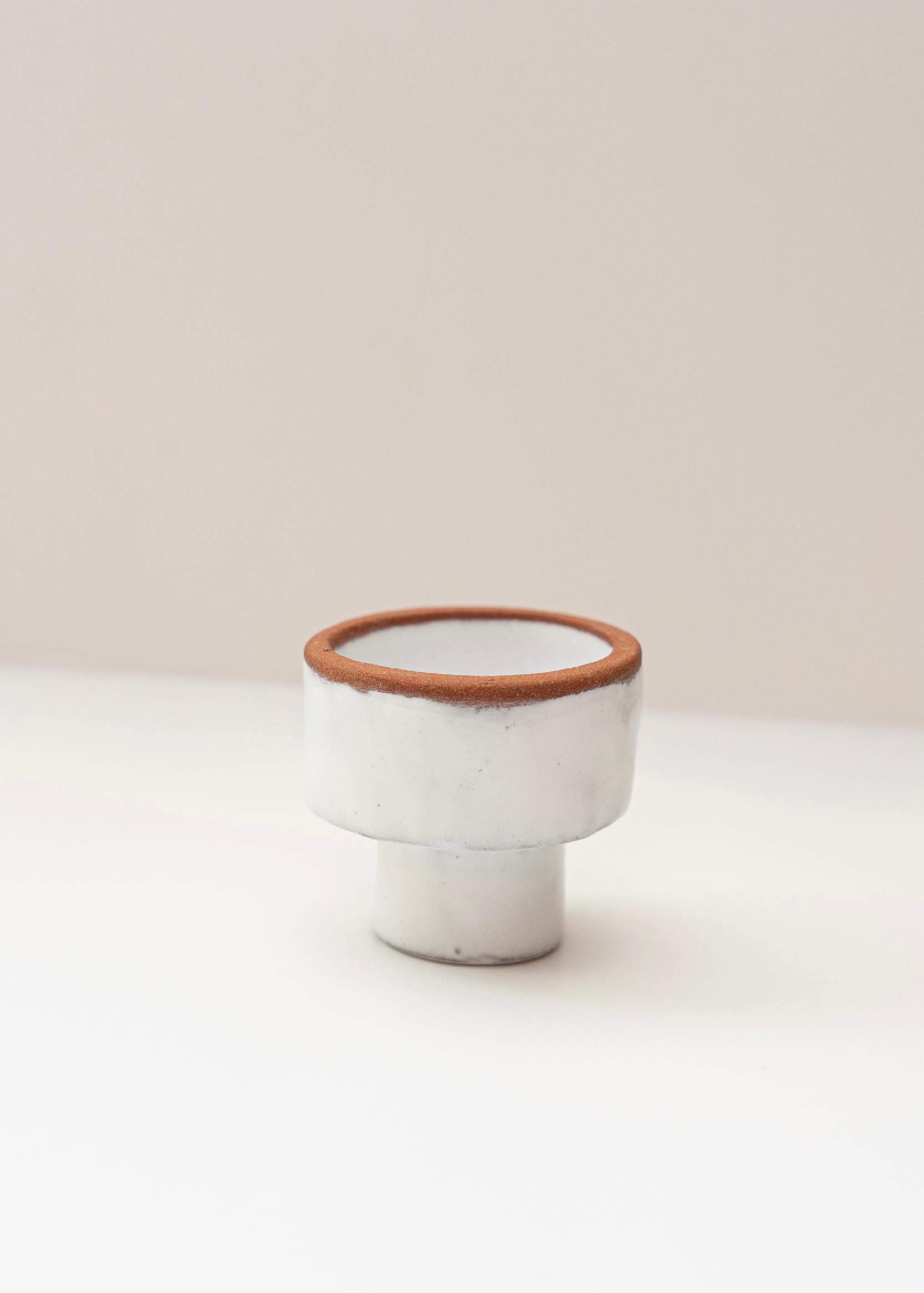 Two-sided white candle holder with a brown rim