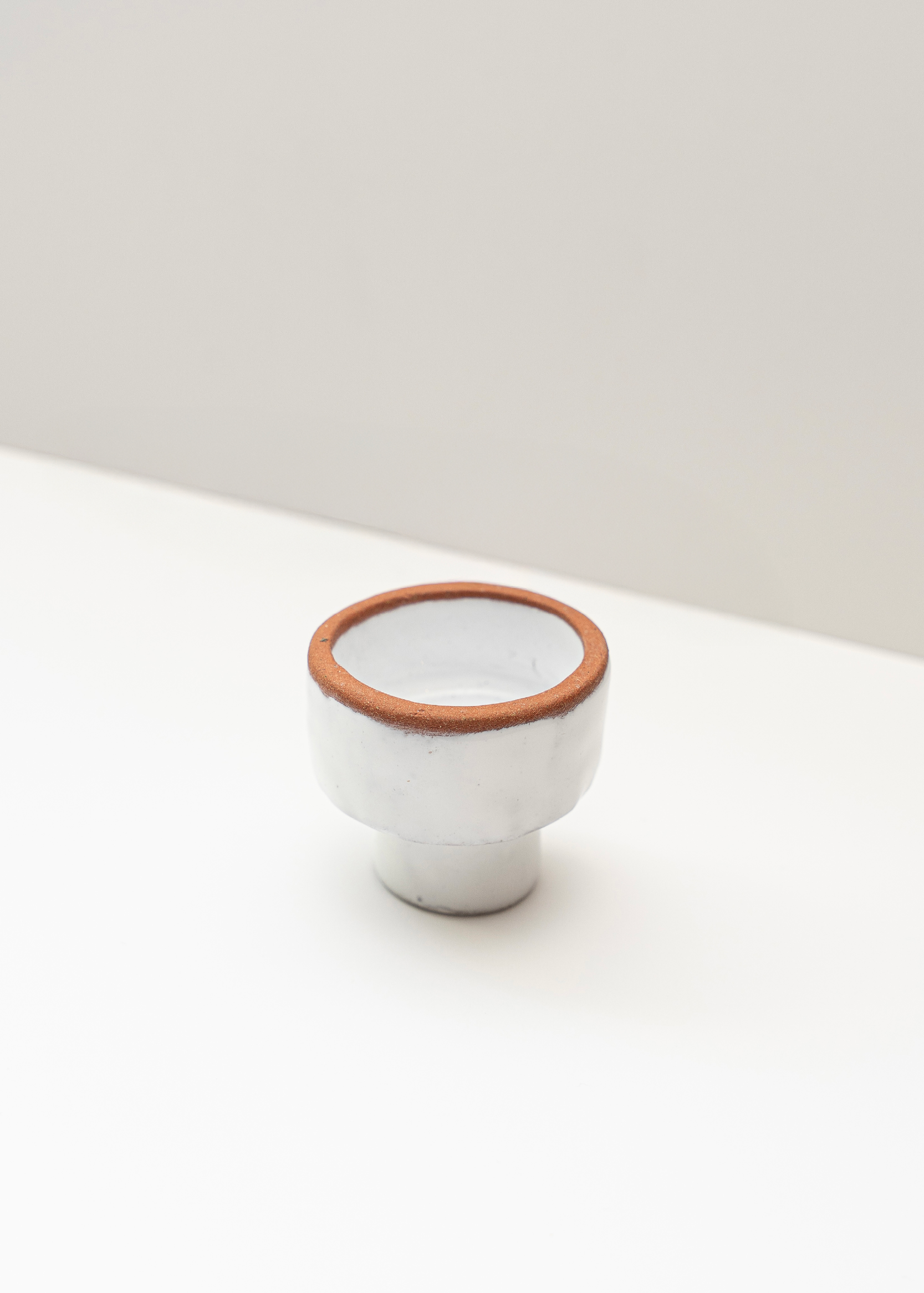 Two-sided white candle holder with a brown rim